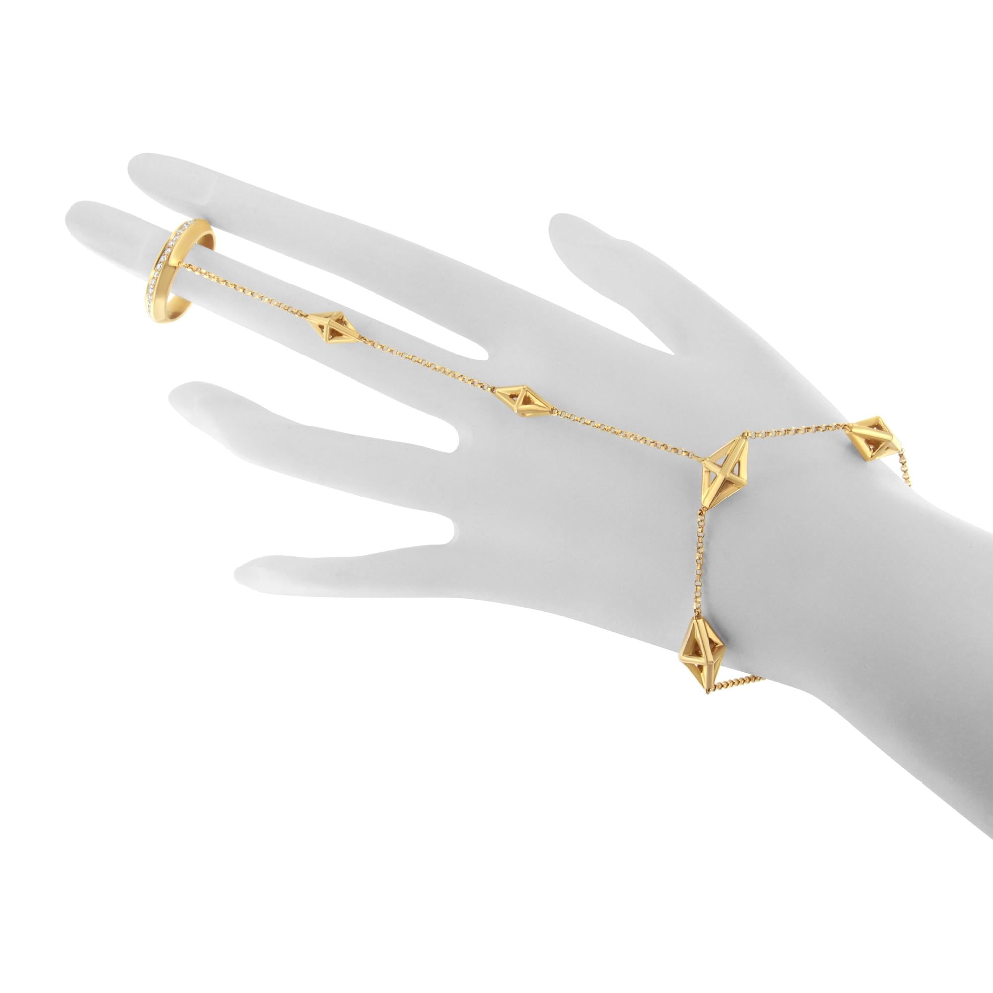 Luxury gold and diamond hand chain bracelet  on a mannequin hand against a white background