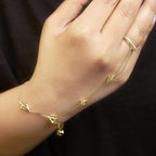 Luxury gold and diamond hand chain bracelet  on a hand against a dark background