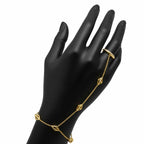 Luxury gold and diamond hand chain bracelet with pyramid designs on a black mannequin hand against a white background