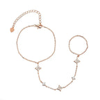 Rose gold hand chain bracelet with star-shaped charms on a white background