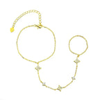 Gold hand chain bracelet with star and arrow designs on a white background