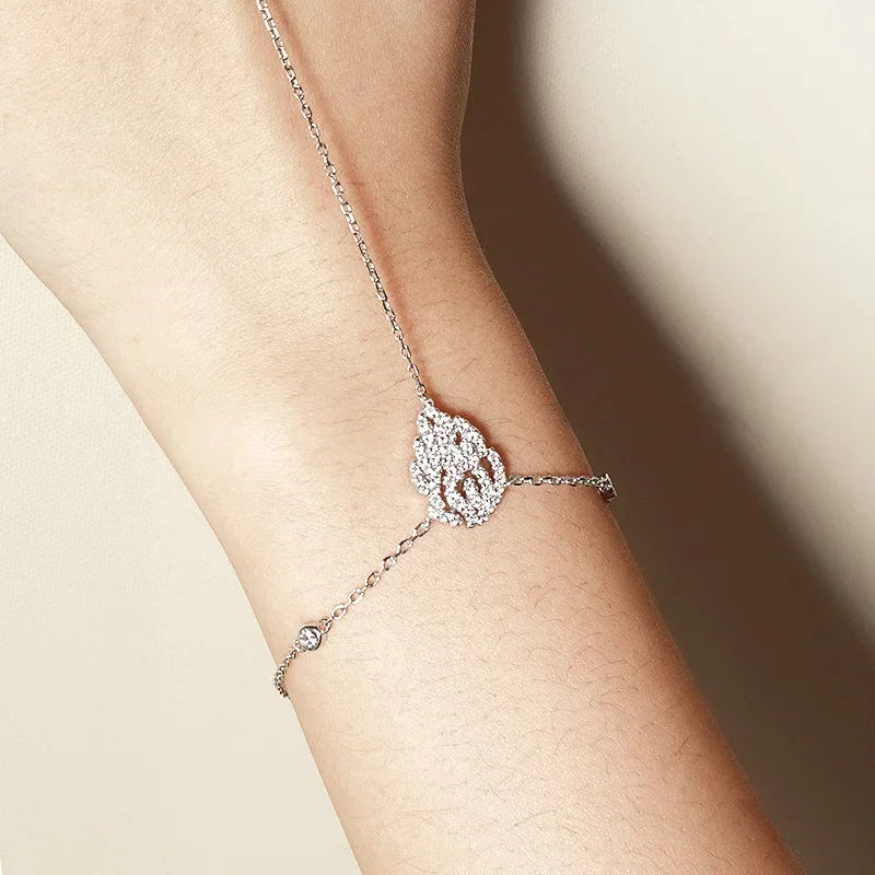 Hand Chain Bracelet in Sterling Silver and white gold with a decorative clasp on a wrist against a neutral background